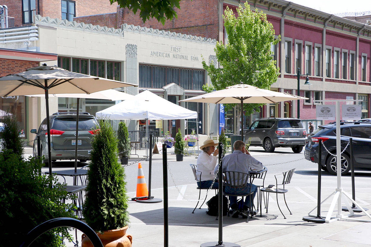 A Port Townsend couple who did not want to be identified enjoy lunch Thursday at the makeshift shaded patio outside the Silverwater Cafe on Taylor Street. (Ken Park/Peninsula Daily News)