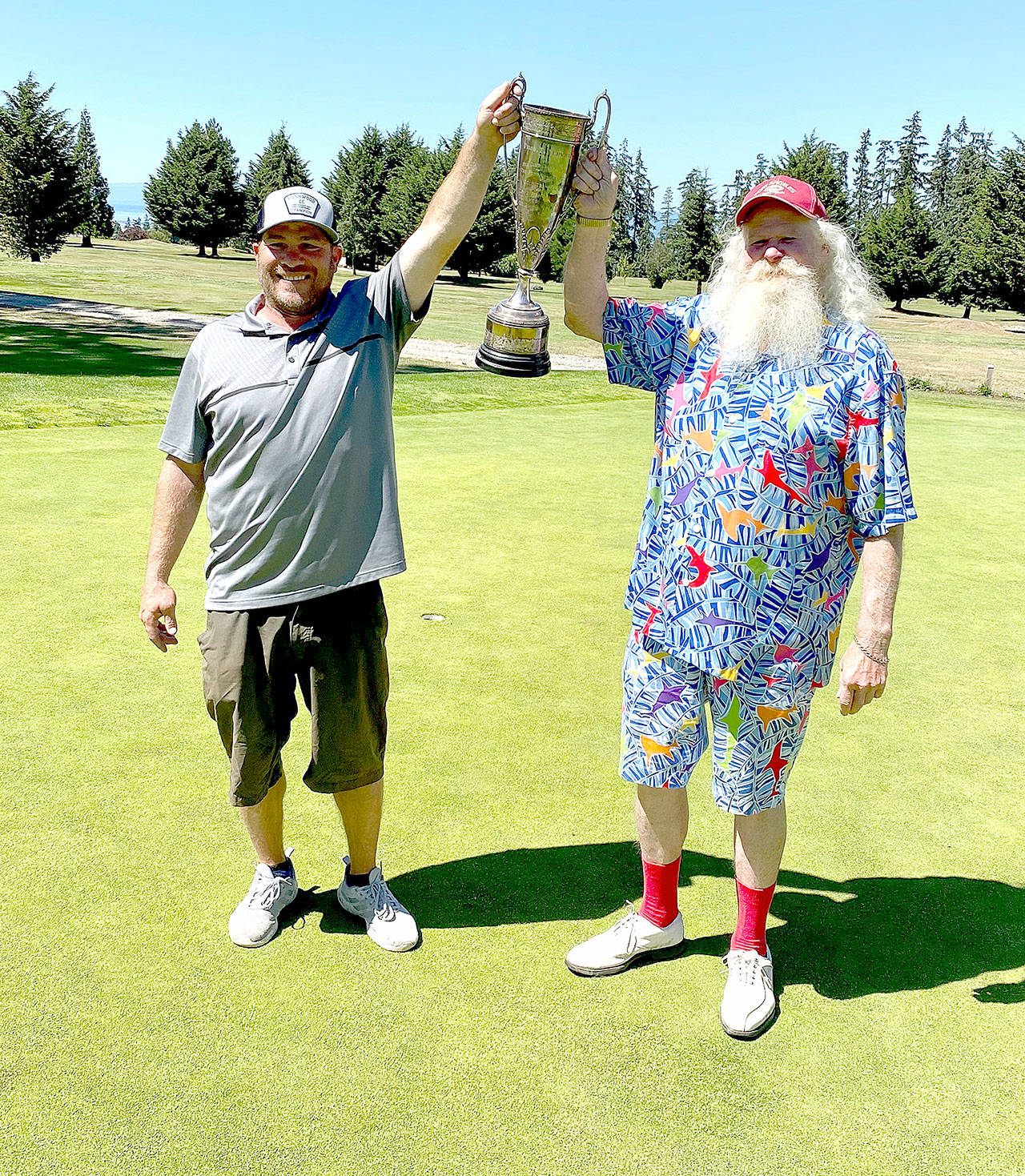 Gross winner Jade Tisdale, left, and net winner Al Osterberg show off their winners’ trophy Sunday at the Port Angeles Golf and Country Club after winning the Men’s Club Championship. (Submitted photo)