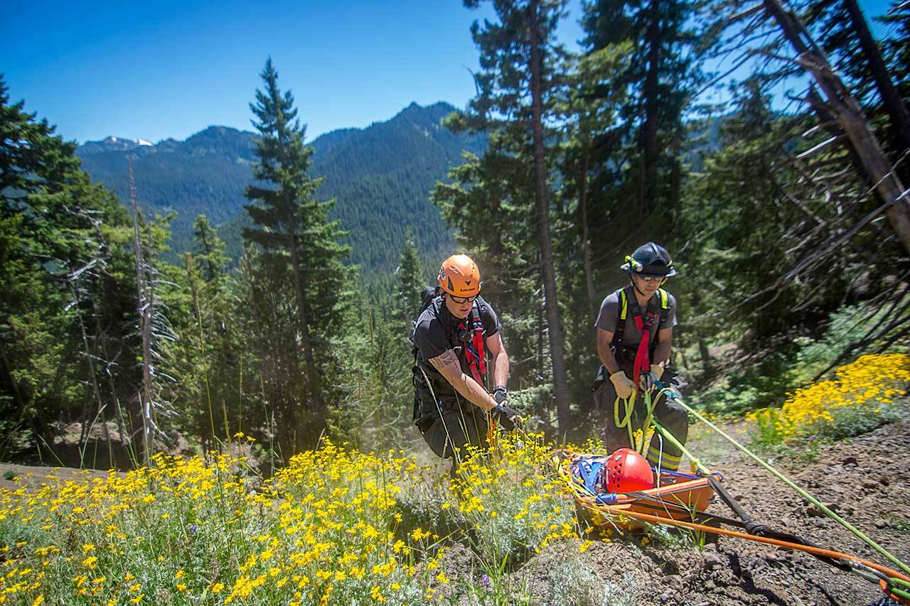 Clallam County Fire District No. 2 assist Olympic National Park rangers in rescuing a woman who fell down an embankment at milepost 13.5 on Hurricane Ridge Road on Sunday, July 26, 2020. The woman was in stable condition and was transferred to Olympic Medical Center for treatment. The road was closed to uphill traffic for about two hours. (Jesse Major)
