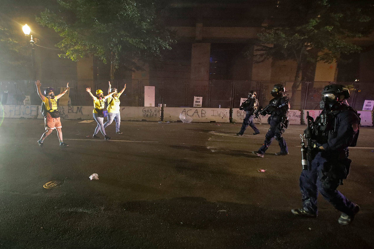 Federal officers advance on members of the “Wall of Moms” group during a Black Lives Matter protest at the Mark O. Hatfield United States Courthouse on Wednesday, July 29, 2020, in Portland, Ore. (Marcio Jose Sanchez/Associated Press)