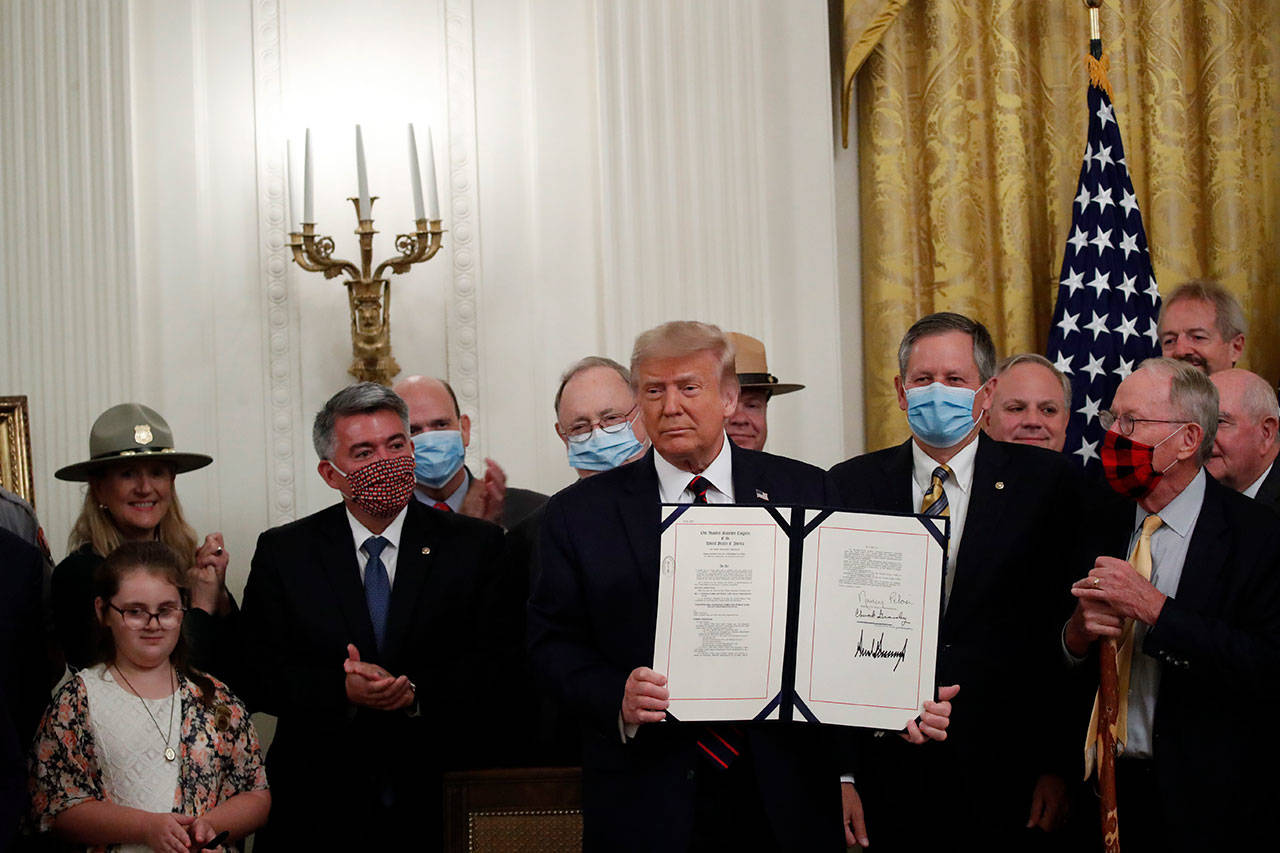 President Donald Trump poses for a photo during a signing ceremony for H.R. 1957 – “The Great American Outdoors Act,” in the East Room of the White House on Tuesday, Aug. 4, 2020, in Washington. (Alex Brandon/The Associated Press)
