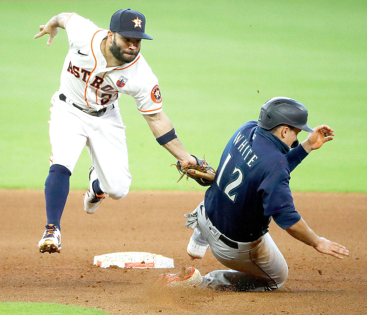 Houston Astros second baseman Jose Altuve, left, catches Seattle Mariners’ Evan White trying to steal in the top of the seventh inning Sunday, Aug. 16, 2020, in Houston. (Kevin M. Cox/The Galveston County Daily News via AP)