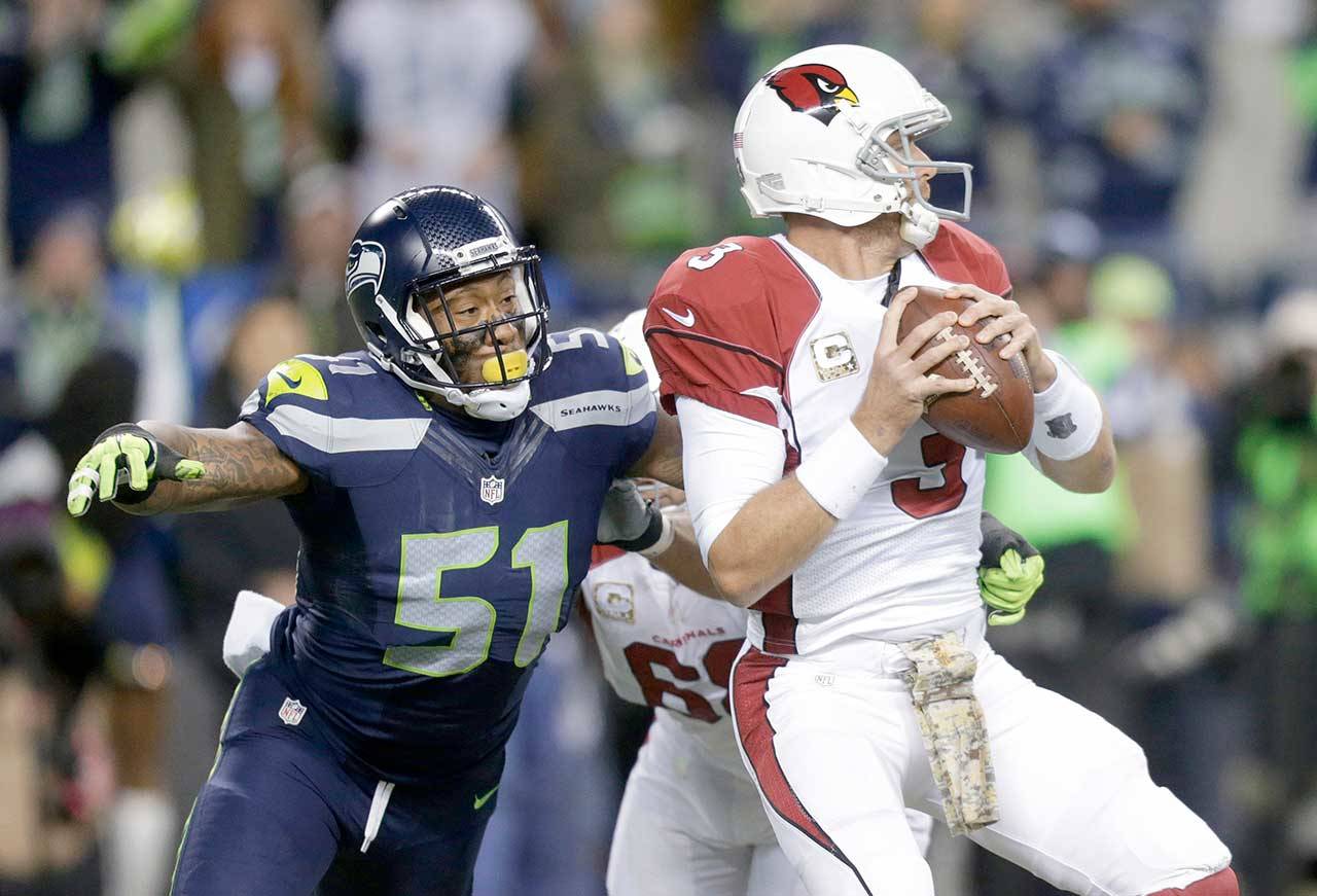 In this Nov. 15, 2015, file photo, Seattle Seahawks outside linebacker Bruce Irvin (51) pressures Arizona Cardinals quarterback Carson Palmer during the first half of an NFL football game in Seattle. Irvin is thrilled to be back where his NFL journey started. Irvin jumped at the chance to return to Seattle this offseason, but his reunion with the Seahawks comes with the expectation he can help a lackluster pass rush. (Stephen Brashear/The Associated Press file)