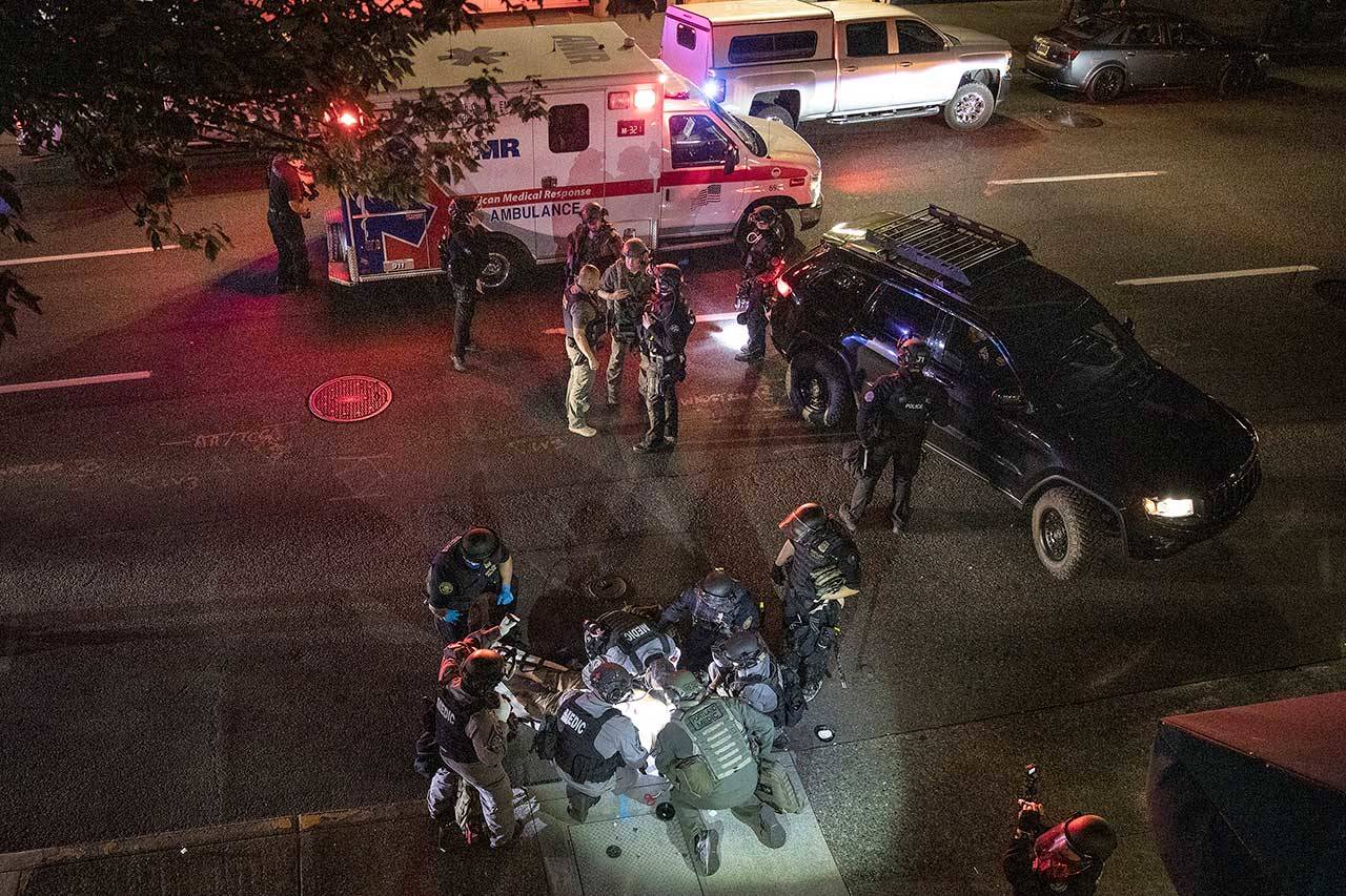 A man is treated after he was shot Saturday in Portland, Ore. It wasn’t clear if the fatal shooting late Saturday was linked to fights that broke out as a caravan of about 600 vehicles was confronted by counter-demonstrators in the city’s downtown. (Paula Bronstein/The Associated Press)