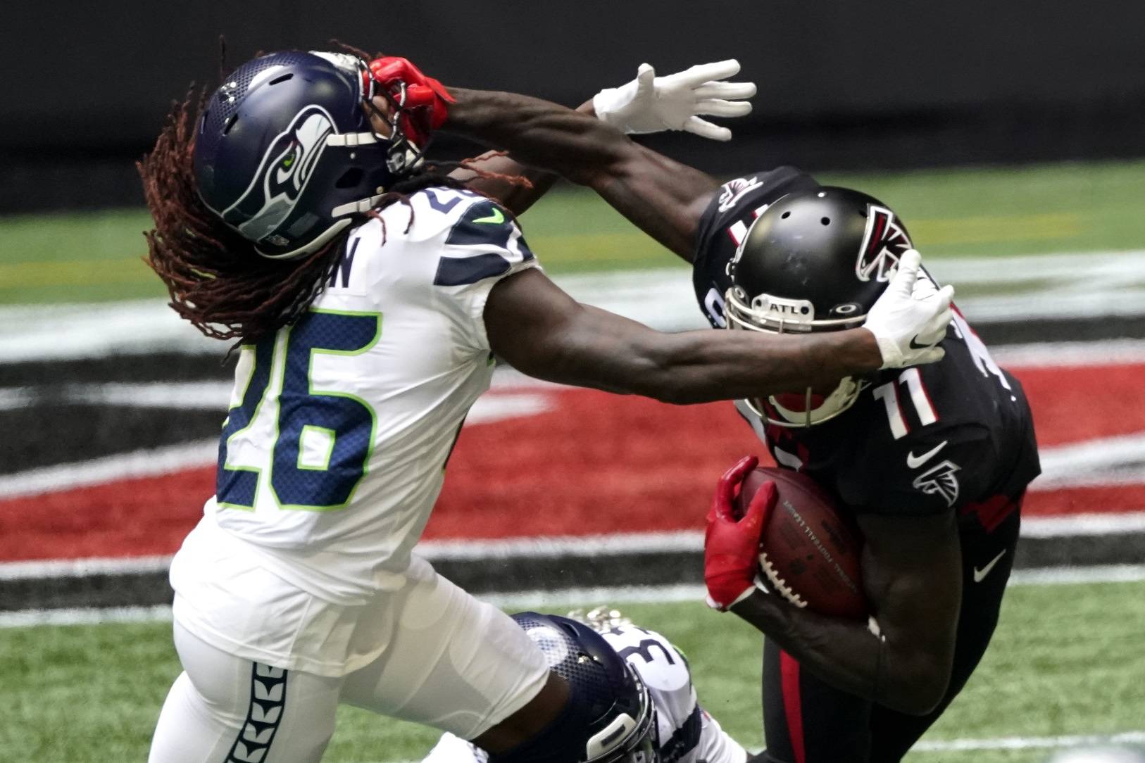 Atlanta Falcons wide receiver Julio Jones (11) grabs the facemask of Seattle Seahawks cornerback Shaquill Griffin (26) during the first half Sunday in Atlanta. (John Bazemore/Associated Press)