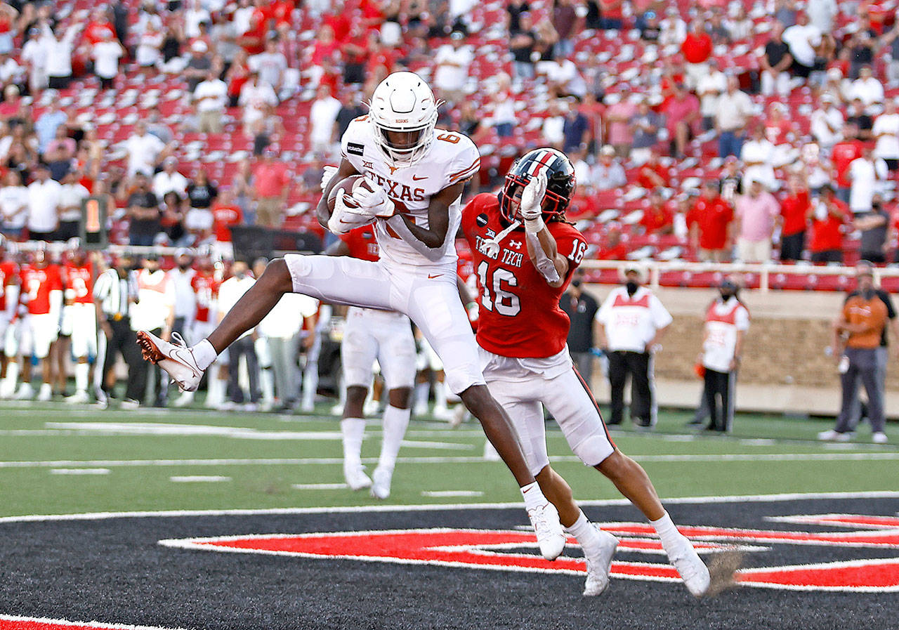 Texas’ Al’Vonte Woodard (9) catches the ball for a touchdown around Texas Tech’s Thomas Leggett (16) during the second half an NCAA college football game Saturday in Lubbock, Texas. (Brad Tollefson/Lubbock Avalanche-Journal via AP)