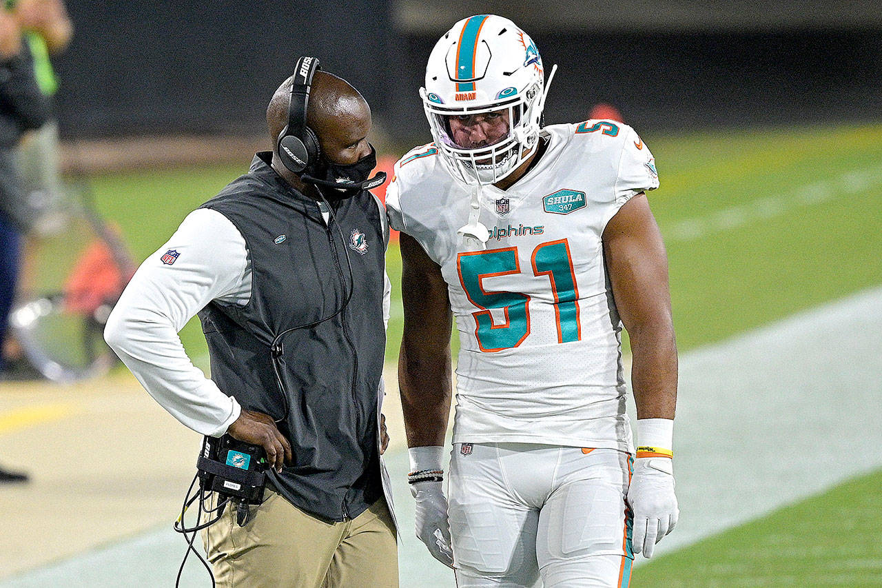 Phelan M. Ebenhack/The Associated Press Miami Dolphins head coach Brian Flores, left, talks with outside linebacker Kamu Grugier-Hill (51) on the sidelines during the first half against the Jacksonville Jaguars, in Jacksonville, Fla., on Sept. 24.