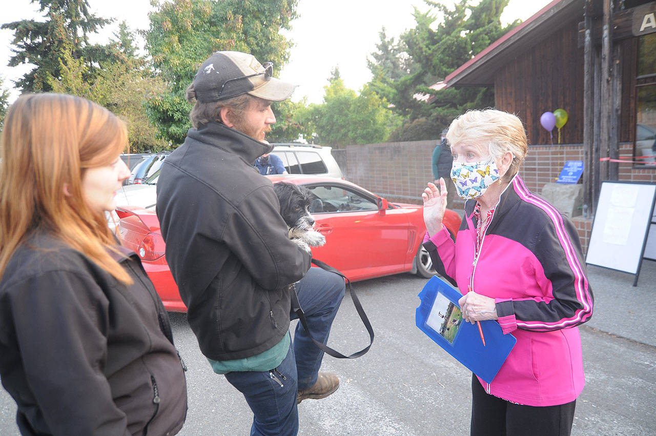 Sharon Palmer, right, who coordinated a spay/neuter clinic for Peninsula Friends of Animals, helps a couple with four dogs get services at Sequim Animal Hospital. (Michael Dashiell/Olympic Peninsula News Group)