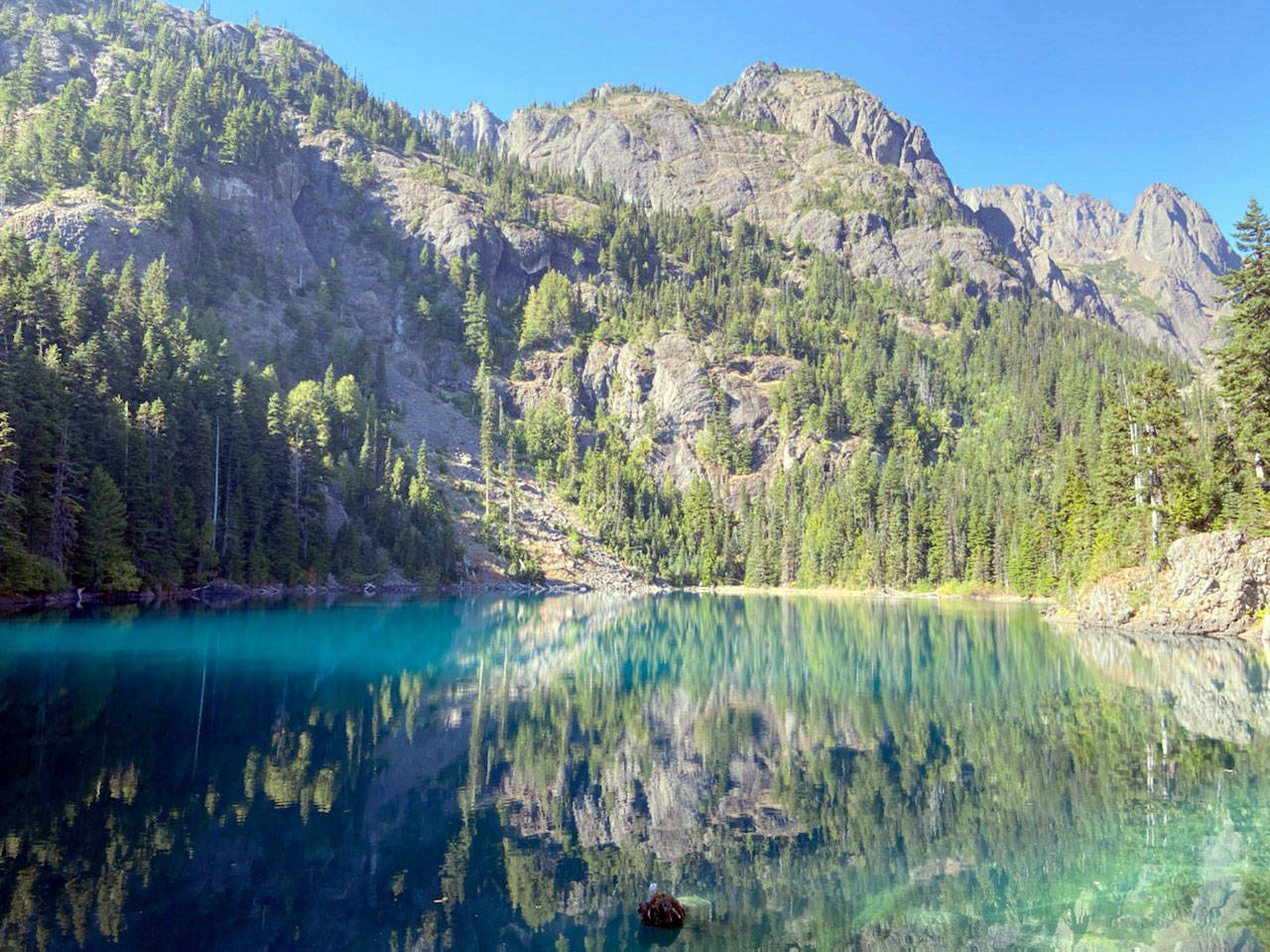 The basalt cliffs of Mount Constance reflect off Lake Constance. (Rob Ollikainen/Peninsula Daily News)
