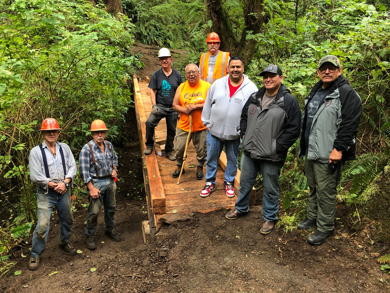 When a footbridge over Lonesome Creek, located on the popular West End’s LaPush Beach Trail, needing replacing, three organizations collaborated on it. Quileute Tribal Council provided materials, including 30-foot-long steel I-beams for the bridge stringers, the Olympic National Park provided the drawings and oversight of the project and Back Country Horsemen Mt Olympus Chapter members provided volunteers to remove the old bridge and replace it with materials that will last many years. From left, Mt. Olympus volunteers Mike McCracken, Larry Baysinger, Rich James and Ray Sutherland (orange hat). Representing the Quileute Tribal Council are, from left, and Tom Jackson, Doug Woodruff, Skylar Foster and Tony Foster. (Sherry Baysinger)