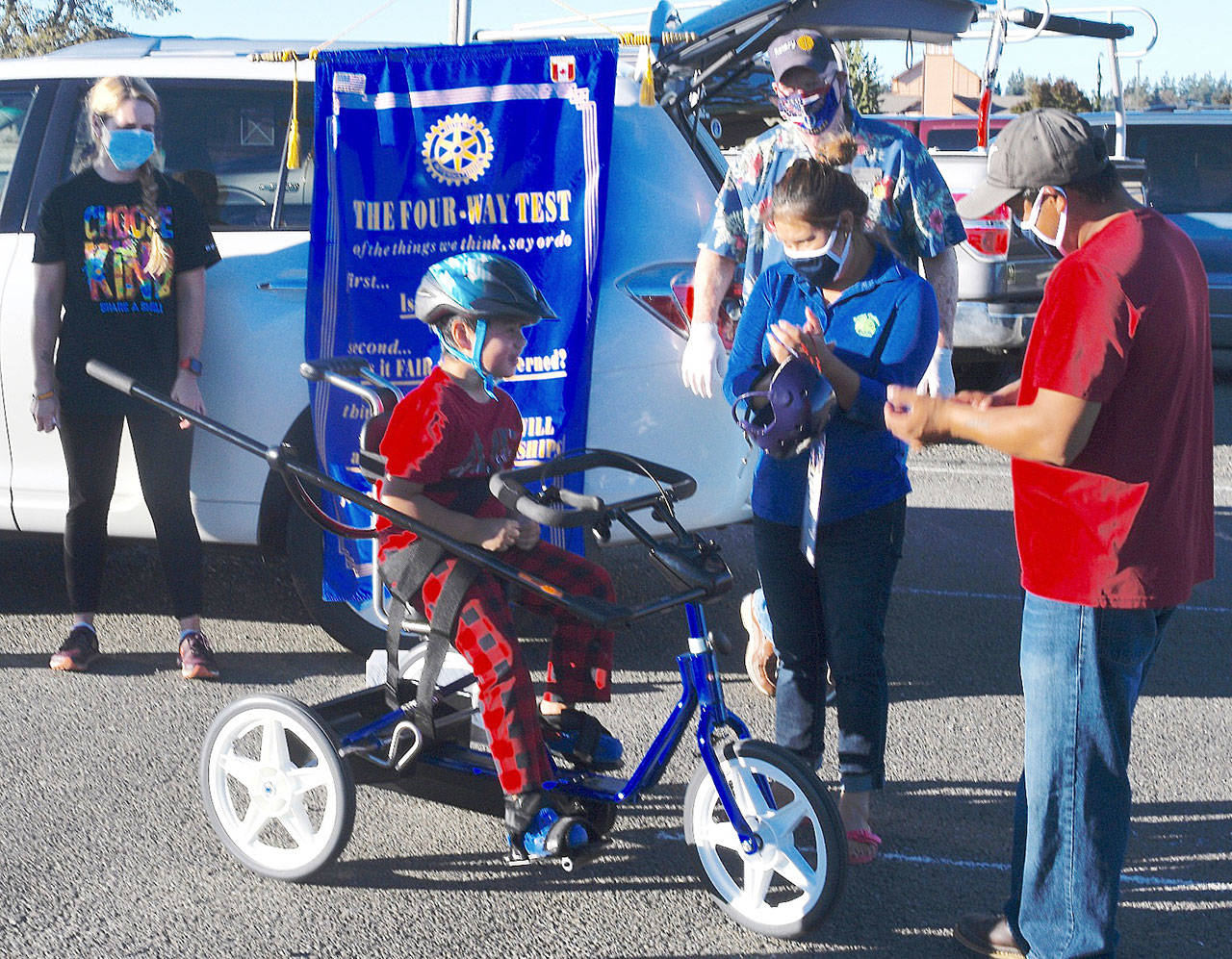 Rodney Torres smiles after riding his new bike, as his parents Mayra and Teles cheer him on. Photo by Doug Schwarz