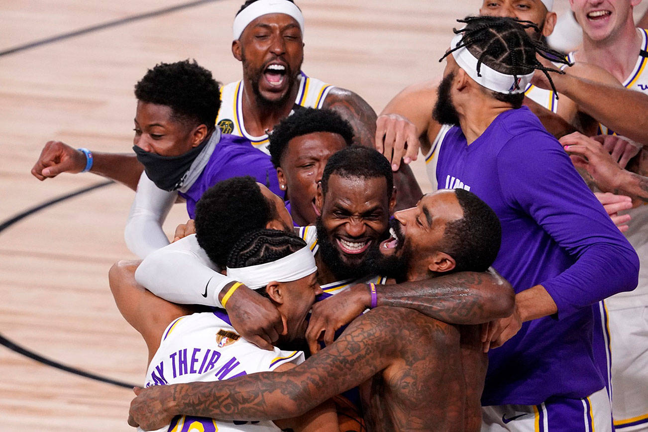 Los Angeles Lakers' LeBron James (23) celebrates with his teammates after the Lakers defeated the Miami Heat 106-93 in Game 6 of basketball's NBA Finals Sunday, Oct. 11, 2020, in Lake Buena Vista, Fla. (AP Photo/Mark J. Terrill)