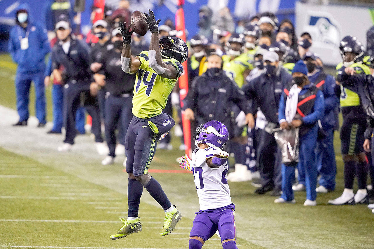 Seattle Seahawks’ DK Metcalf (14) pulls in a long pass reception on the Seahawks’ last series of an NFL football game as Minnesota Vikings’ Cameron Dantzler defends late in the second half Sunday, Oct. 11, 2020, in Seattle. The Seahawks won 27-26. (Ted S. Warren/Associated Press)