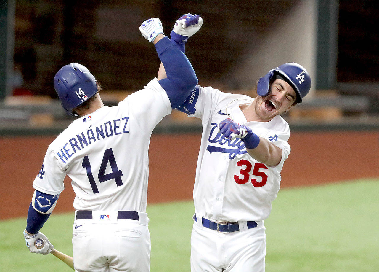 Los Angeles Dodgers’ Cody Bellinger, right, celebrates his solo home run with Enrique Hernandez against Atlanta Braves relief pitcher Chris Martin during the seventh inning in Game 7 of the National League Championship Series Sunday in Arlington, Texas. (Curtis Compton/Atlanta Journal-Constitution via AP)