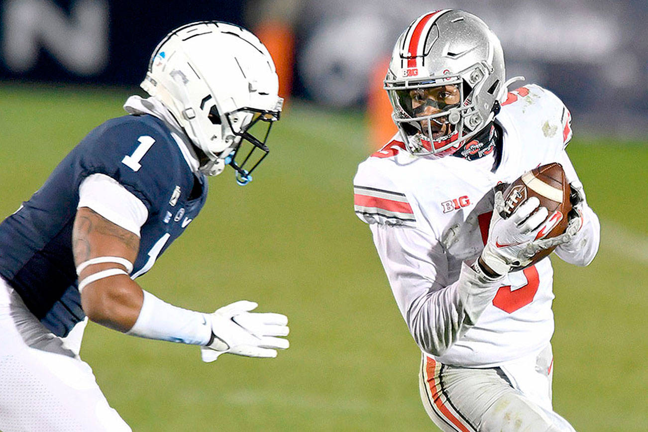 Ohio State wide receiver Garrett Wilson (5) catches a pass in front of Penn State safety Jaquan Brisker (1) during the fourth quarter of an NCAA college football game in State College, Pa., Saturday, Oct. 31, 2020. Ohio State won 38-25. (AP Photo/Barry Reeger)