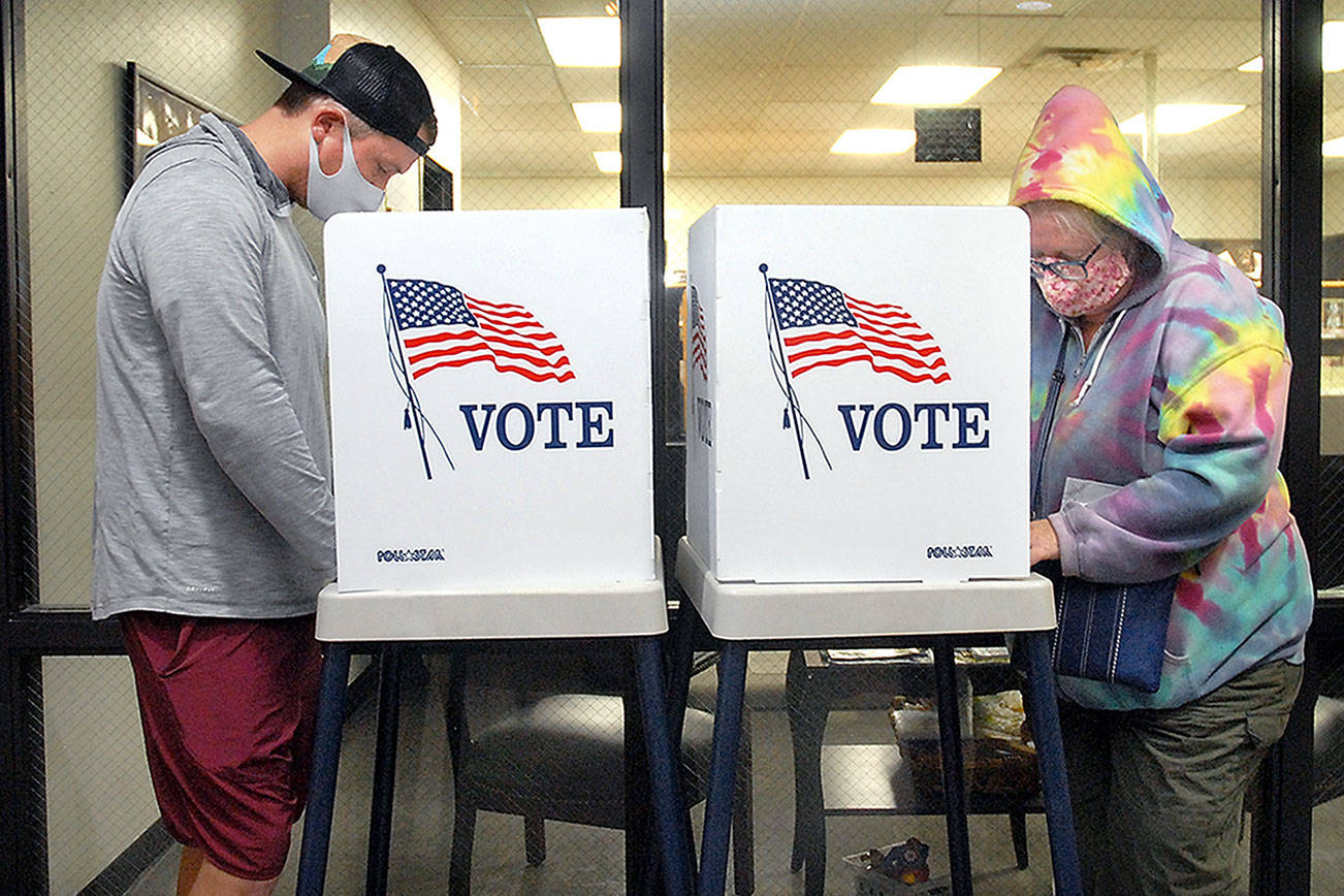 Danny Romero, left, and Petal Ruch, both of Port Angeles, fill out ballots at portable polling stations at the Clallam County Courthouse in Port Angeles on Election Day. (Keith Thorpe/Peninsula Daily News)
