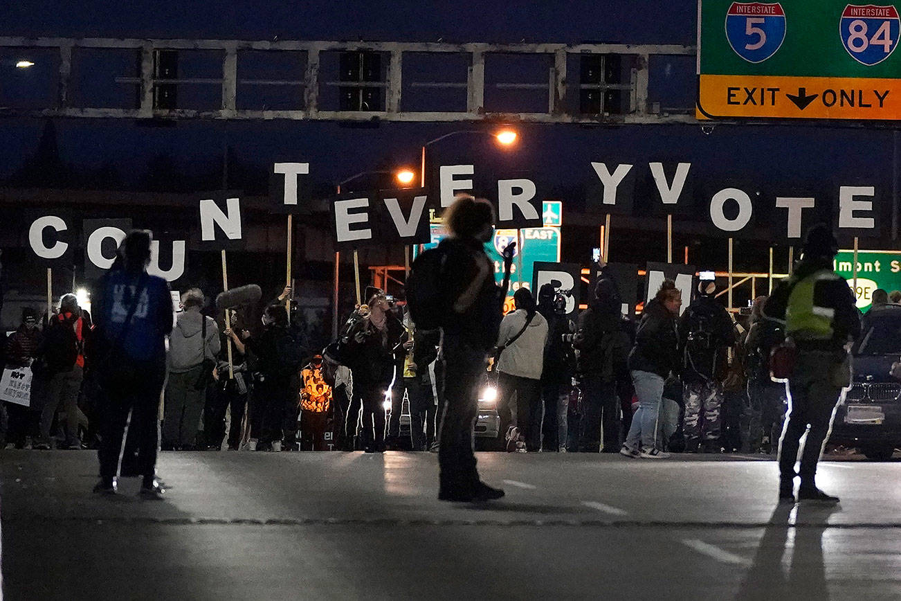 Protesters hold letters that spell Count Every Vote as they cross an overpass while marching in Portland, Ore., Wednesday, Nov. 4, 2020, following Tuesday's election. (AP Photo/Marcio Jose Sanchez)