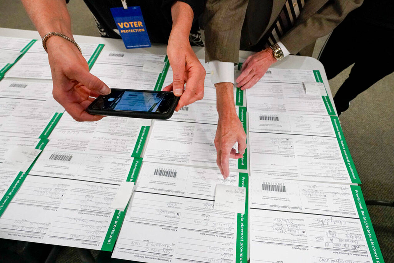 A canvas observer photographs Lehigh County provisional ballots as vote counting in the general election continued Friday, Nov. 6, 2020, in Allentown, Pa. (Mary Altaffer/Associated Press)