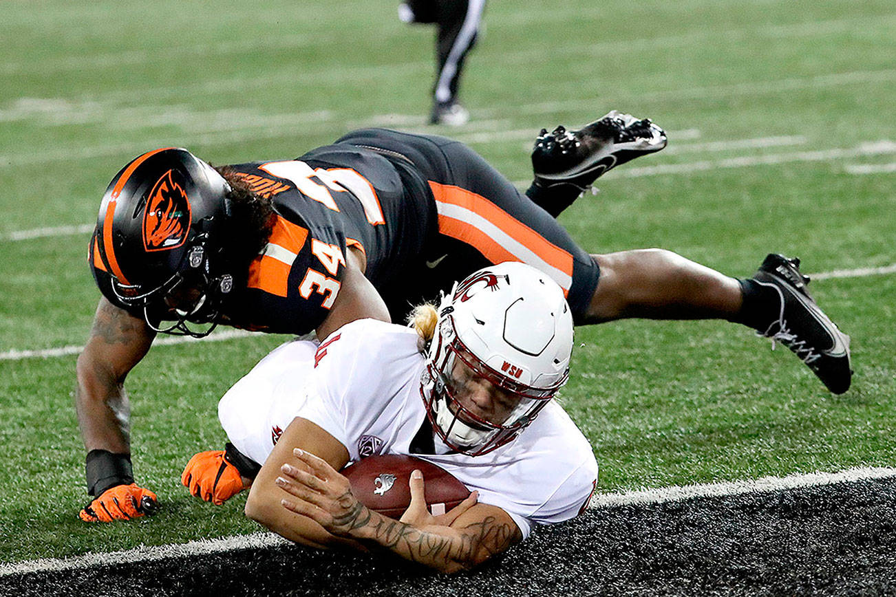 Washington State quarterback Jayden de Laura (4) slides into the end zone, under Oregon State inside linebacker Avery Roberts (34) during the second half of an NCAA college football game in Corvallis, Ore., Saturday, Nov. 7, 2020. Washington State won 38-28. (AP Photo/Amanda Loman)