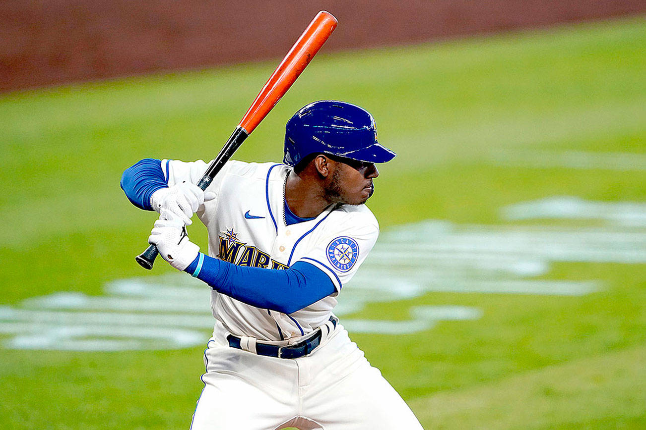 The Seattle Mariners' Kyle Lewis begins his swing on a solo home run against the Texas Rangers on Aug. 23. Lewis won the AL Rookie of the Year award on Monday. (Ted S. Warren/The Associated Press)