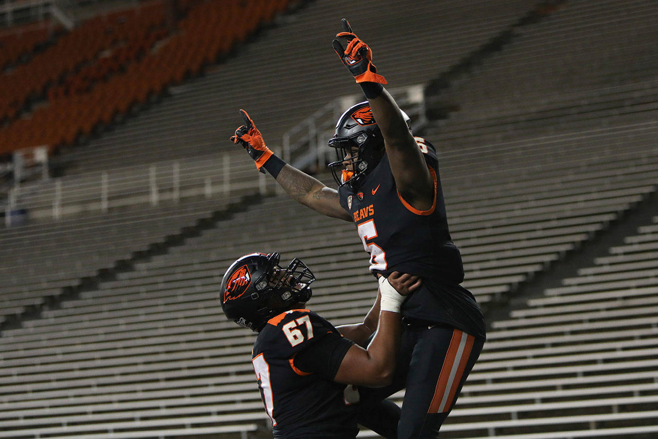 Oregon State offensive linesman Joshua Gray (67) lifts Oregon State running back Jermar Jefferson (6) into the air after Jefferson scored a touchdown during the second half of an NCAA college football game against Washington State in Corvallis, Ore., on Saturday, Nov. 7, 2020. Washington State won 38-28. (Amanda Loman/Associated Press)