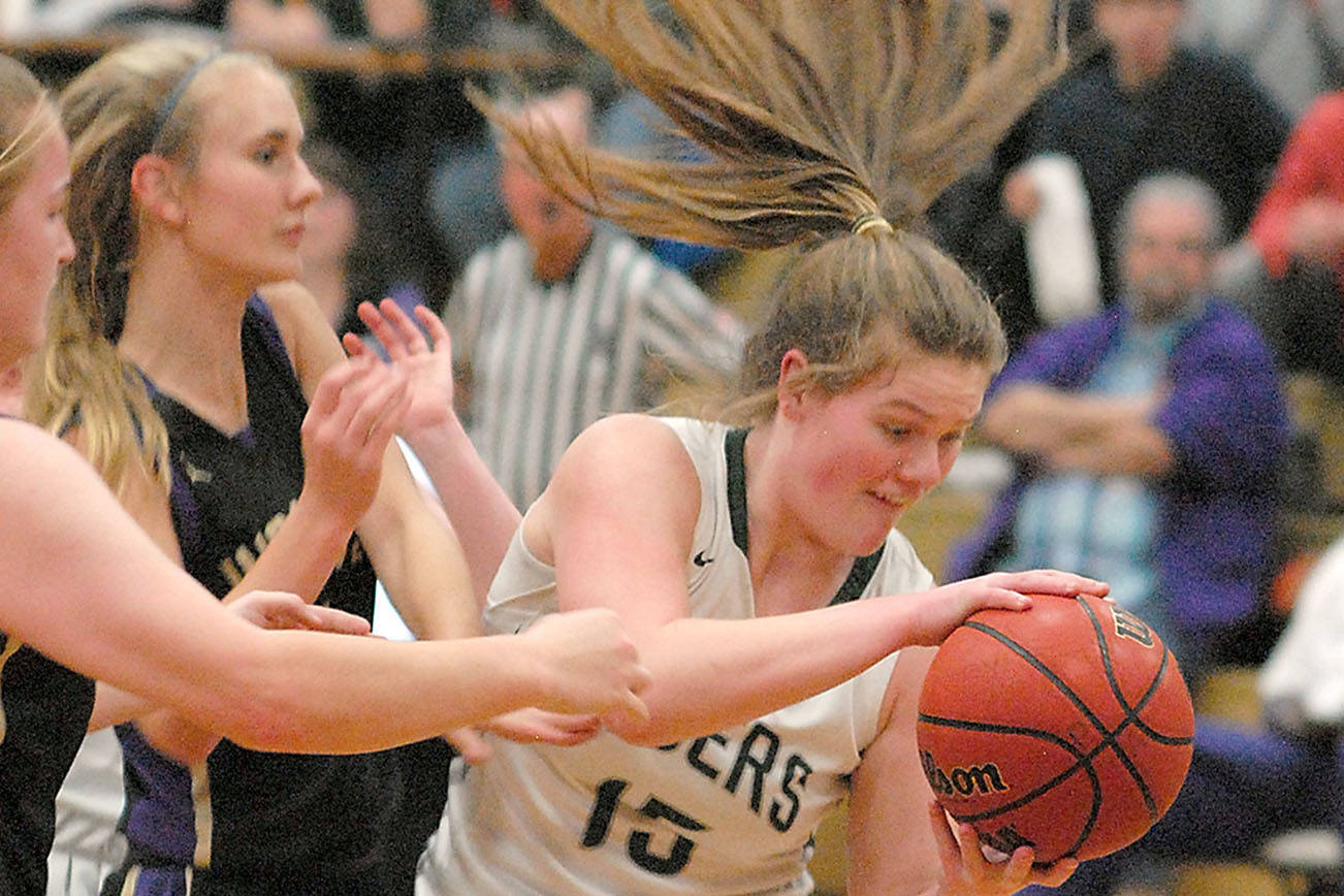 Port Angeles' Myra Walker, right, grabs a rebound from Sequim's LeeAnn Raney, left, and Hannah Wagner during a game last February at Port Angeles High School. (Keith Thorpe/Peninsula Daily News)