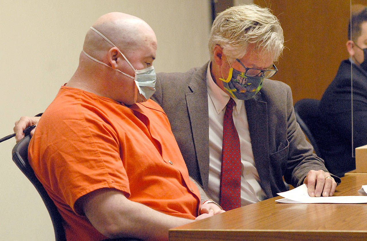 Ryan Warren Ward, left, looks over court papers with attorney Lane Wolfley during Ward’s sentencing for three counts of aggravated first-degree murder and multiple counts of theft and firearms violations on Thursday in Clallam County Superior Court in Port Angeles. (Keith Thorpe/Peninsula Daily News)
