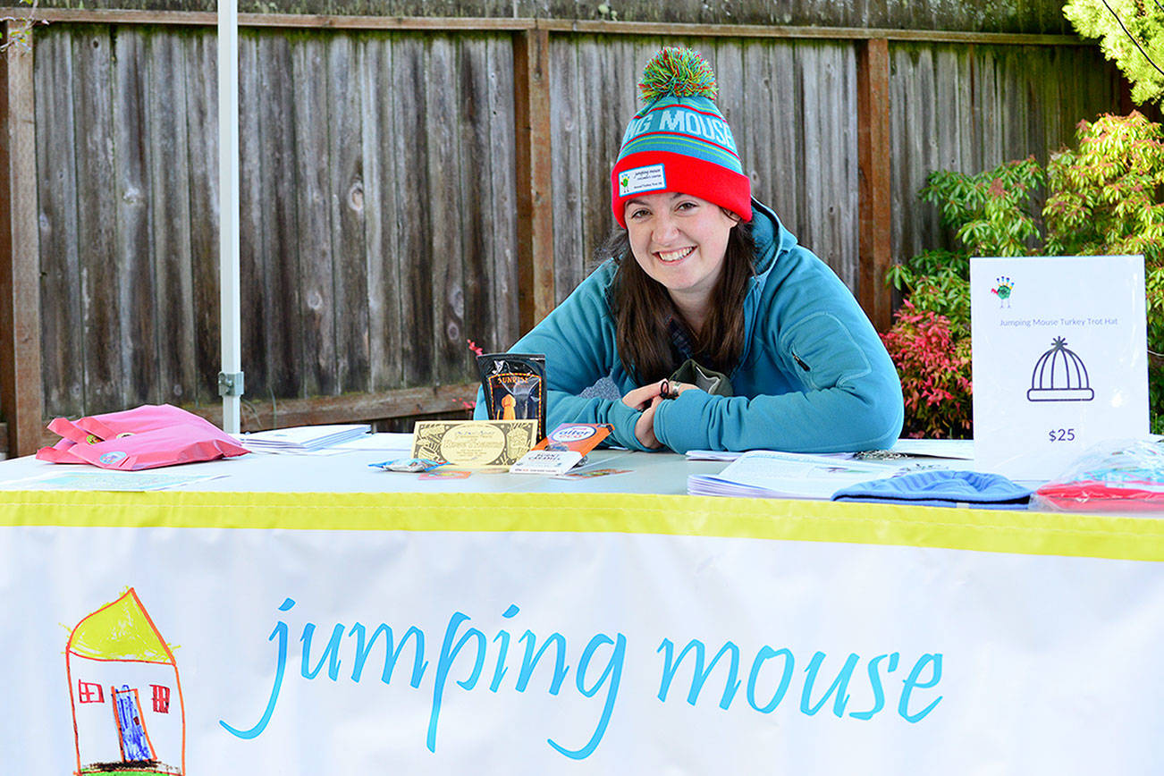 Jumping Mouse Children's Center race director Whitney Friddle shows off contents of the Turkey Trot virtual fun run goodie bag: coffee, chocolate and a popcorn gift certificate from local businesses. The 5K run/walk and family scavenger hunt will happen all of Thanksgiving week. (Diane Urbani de la Paz/Peninsula Daily News)