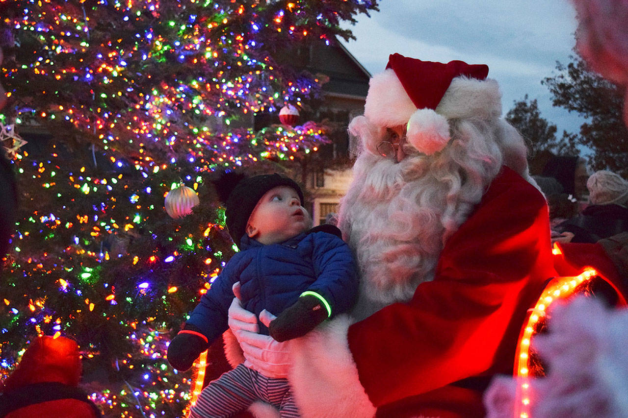 Magic moments like this between Dylan Krashan and Santa Claus in 2018 won’t happen this year at the downtown Sequim tree lighting event due to pandemic protocols coming into place. The tree lighting moves online to 5 p.m. on Thanksgiving at the Sequim-Dungeness Valley Chamber of Commerce’s website and social media pages. (Olympic Peninsula News Group file photo)