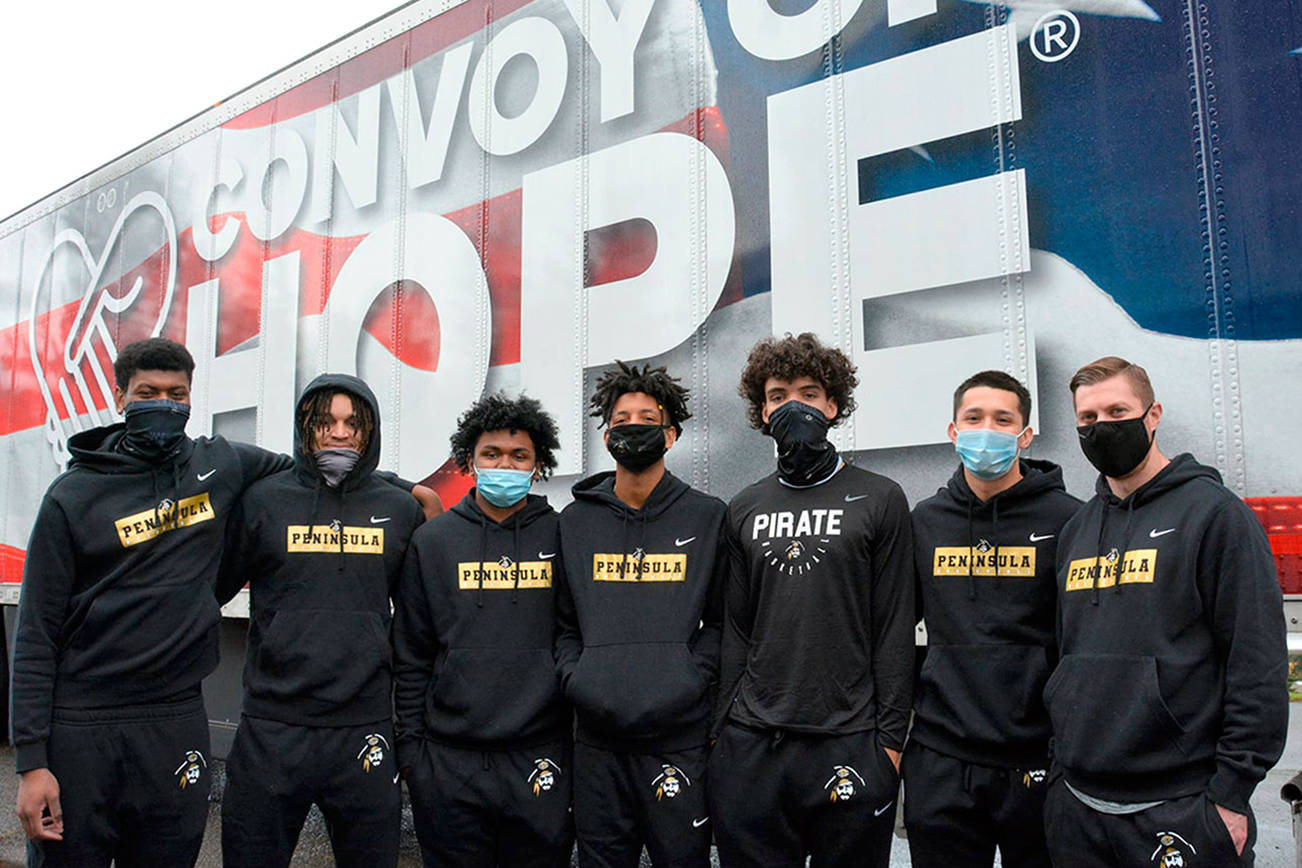 Peninsula College men's basketball players recently assisted Port Angeles' Lighthouse Christian Center and Convoy of Hope volunteers and staff in setting up non-perishable grocery items for distribution to the community. Pirate players are from left, Isaiah Sampson, Jaylin Reed, Lewis Welsh, Mikey Medlock, KeAndre Hunter-Holliday, Neal Garcia and Coach Donald Rollman.