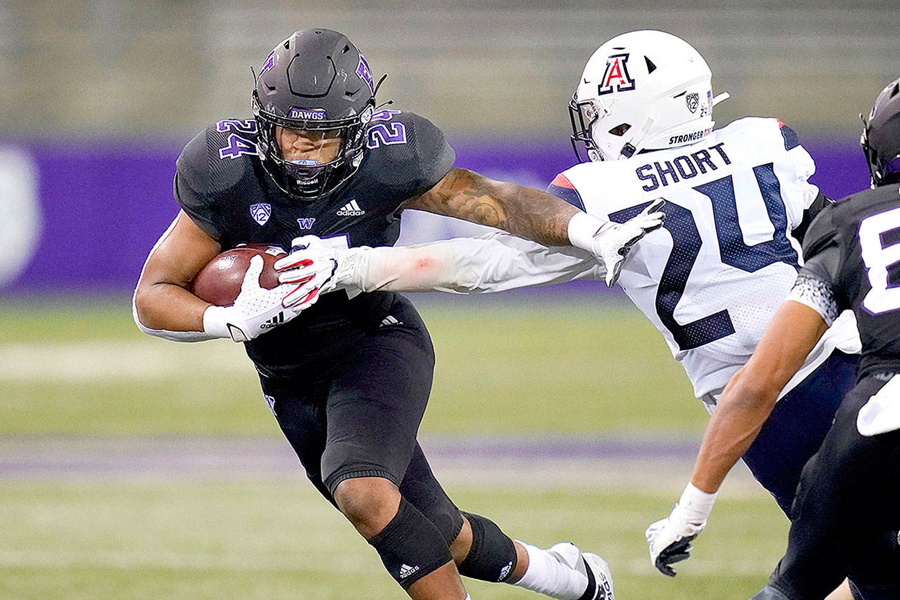 Washington's Kamari Pleasant, left, pushes away Arizona's Rhedi Short on Pleasant's 21-yard touchdown run during the second half of an NCAA college football game Saturday, Nov. 21, 2020, in Seattle. (AP Photo/Elaine Thompson)