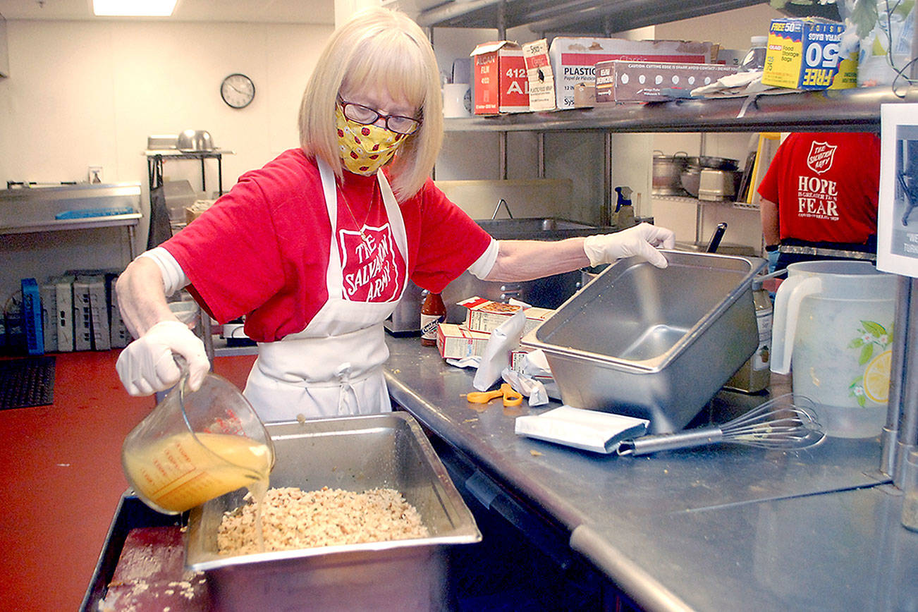Volunteer Phyllis Meyer of Sequim adds broth to make stuffing for Wednesday's traditional Thanksgiving Eve lunch at the Port Angeles Salvation Army. (Keith Thorpe/Peninsula Daily News)