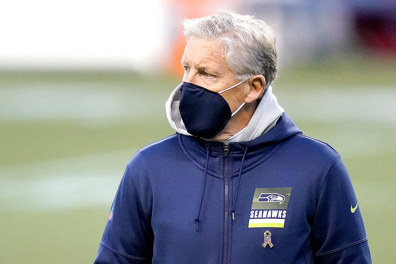 Seattle Seahawks head coach Pete Carroll wears a mask on the field before an NFL football game against the Arizona Cardinals on Thursday, Nov. 19, 2020, in Seattle. (Elaine Thompson/The Associated Press)