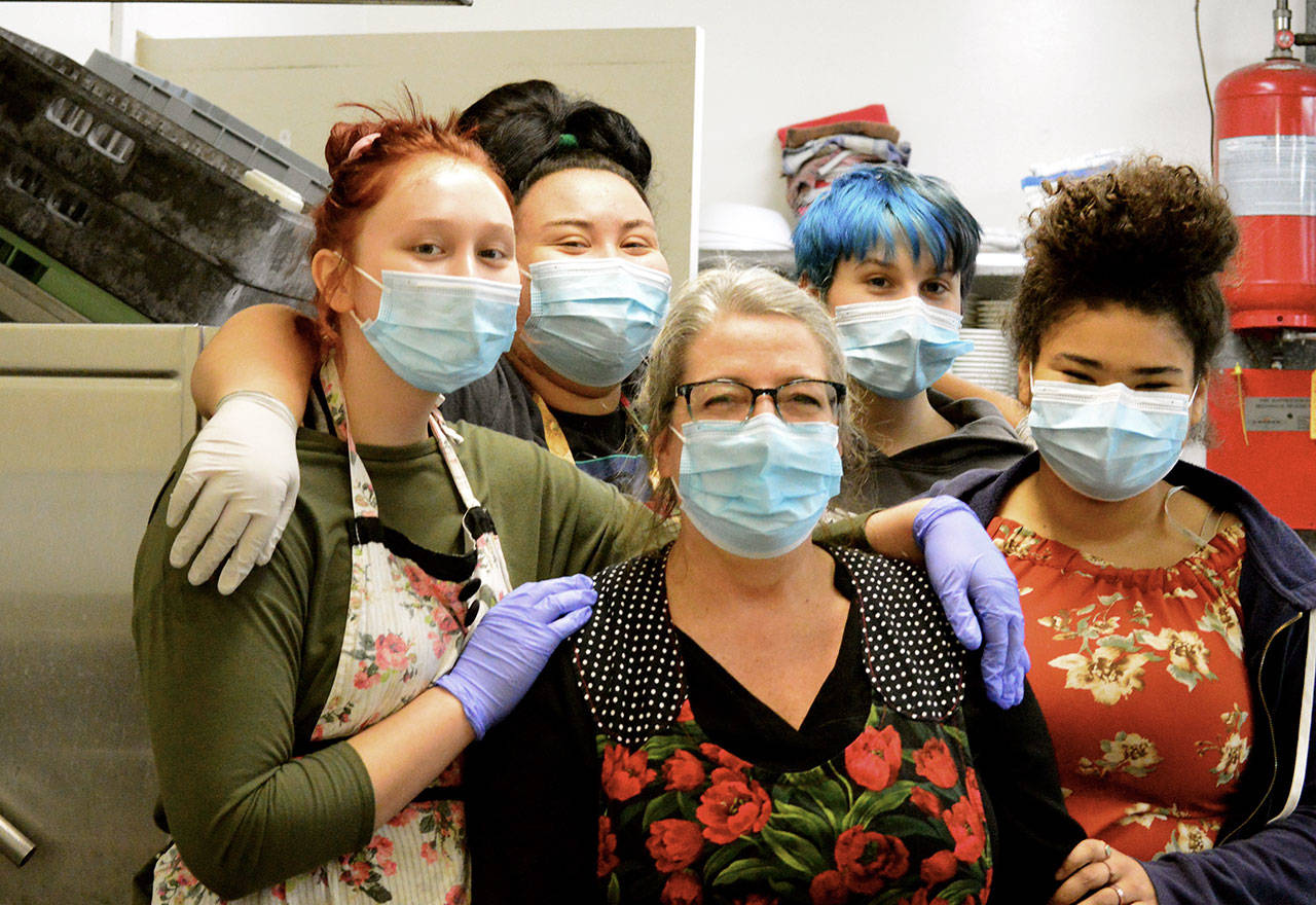Working on Thanksgiving in the Tri-Area Community Center kitchen are Anita Schmucker, center, and her foster kids, from left, Mya, Rosemary, Friday and Sadie. The family helped prepare some 300 dinners at the Chimacum center Thursday. (Diane Urbani de la Paz/Peninsula Daily News)