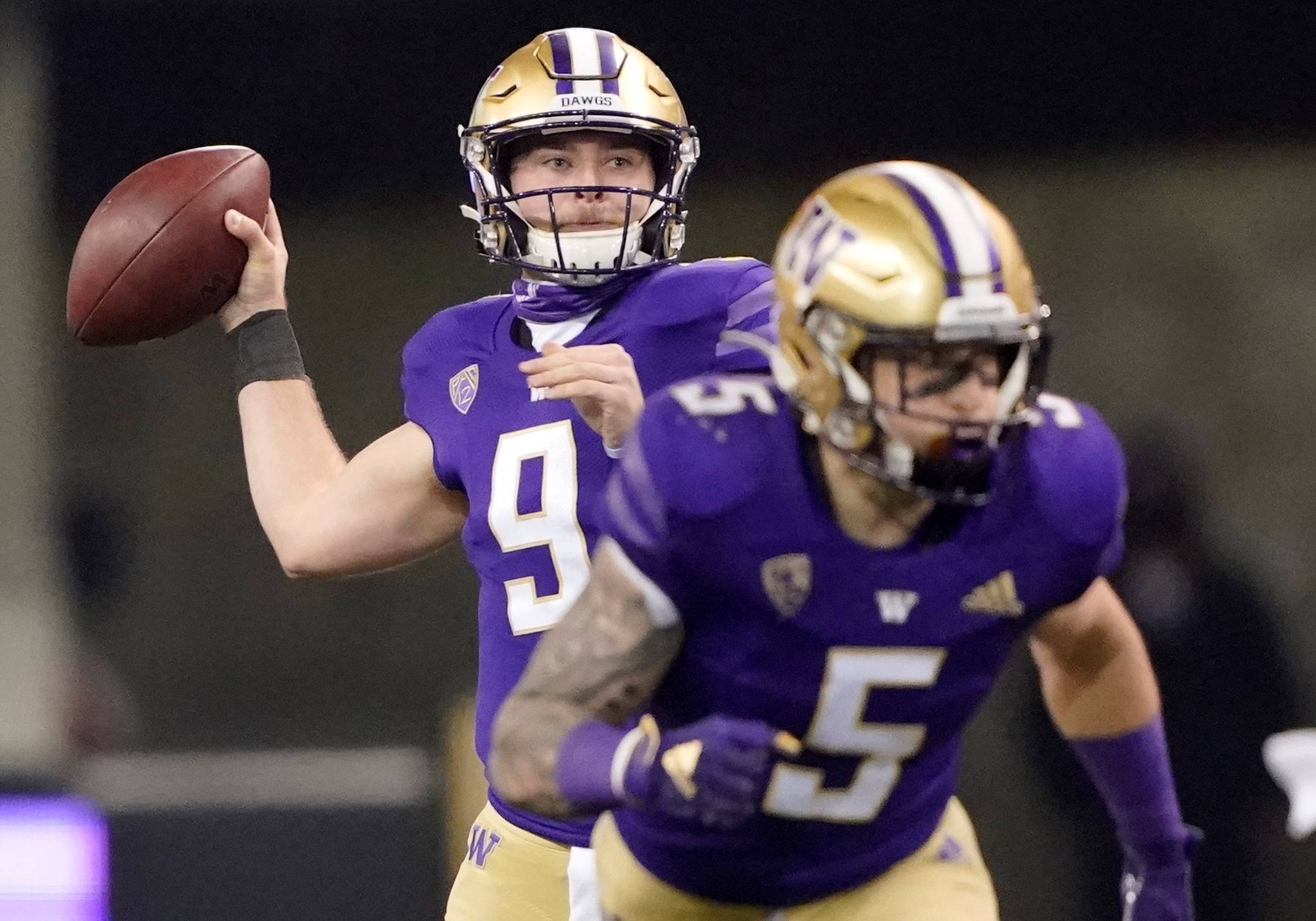 Washington quarterback Dylan Morris, left, drops to pass as running back Sean McGrew (5) takes off from the line of scrimmage during the second half of an NCAA college football game against Utah, Saturday, Nov. 28, 2020, in Seattle. (AP Photo/Ted S. Warren)