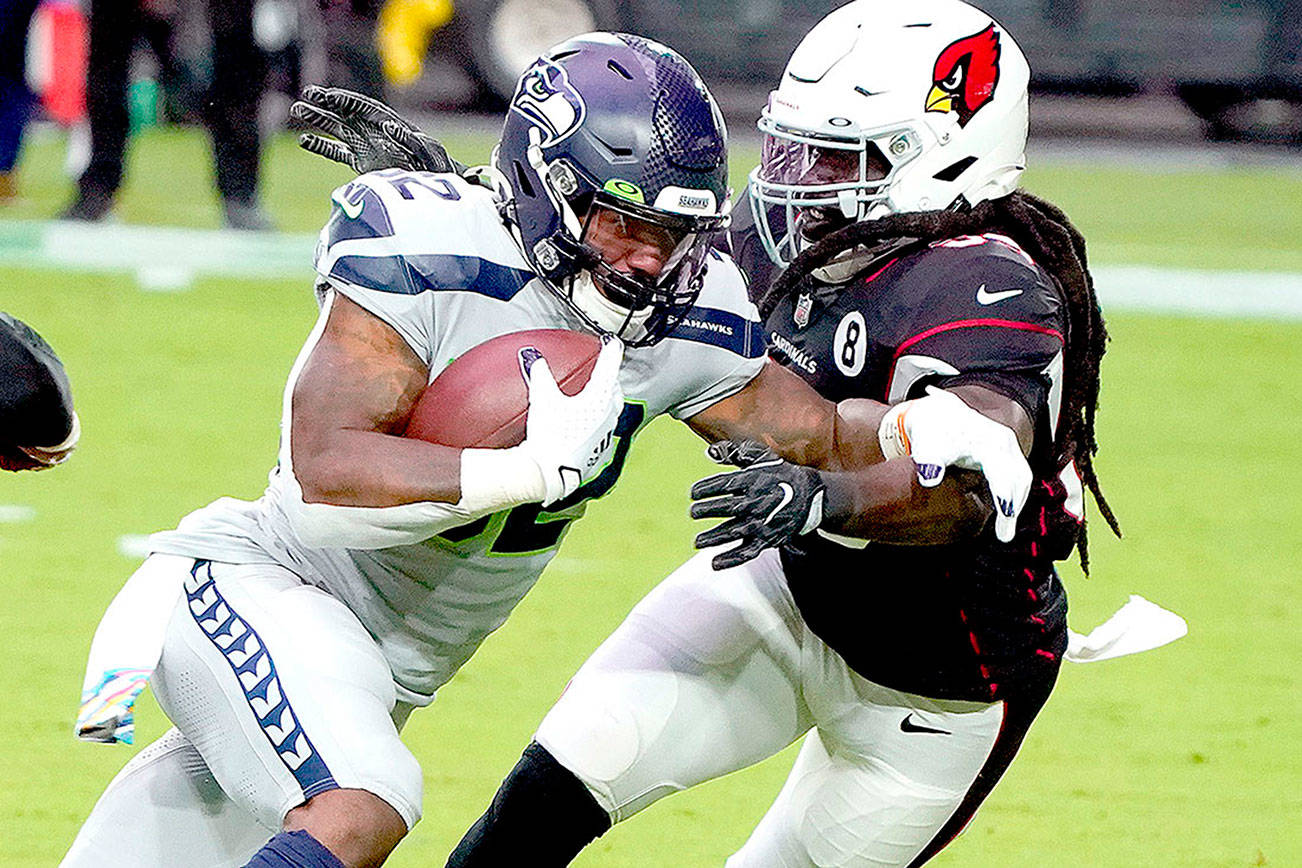 Seattle Seahawks running back Chris Carson (32) runs as Arizona Cardinals outside linebacker De'Vondre Campbell defends during the first half of an NFL football game, Sunday, Oct. 25, 2020, in Glendale, Ariz. (AP Photo/Rick Scuteri)