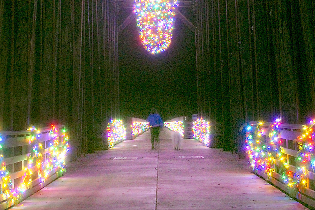 Illuminated wreaths and decorative lights adorn the bridge at Railroad Bridge Park in Sequim, the centerpiece of a holiday display that will be lit from 3 p.m. to 9 p.m. daily through January. The decorations are sponsored by the Jamestown S'Klallam Tribe and were installed by Patrick Walker, Inc., of Port Orchard. (Keith Thorpe/Peninsula Daily News)