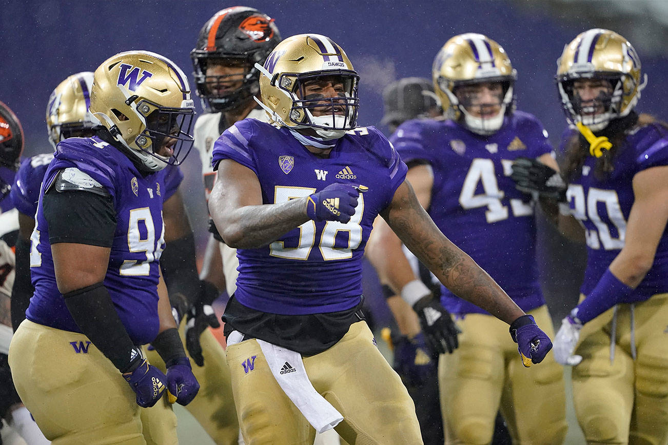 Washington's Sam Taimani, left, and Zion Tupuola-Fetui (58) react against Oregon State during the first half of an NCAA college football game, Saturday, Nov. 14, 2020, in Seattle. (AP Photo/Ted S. Warren)