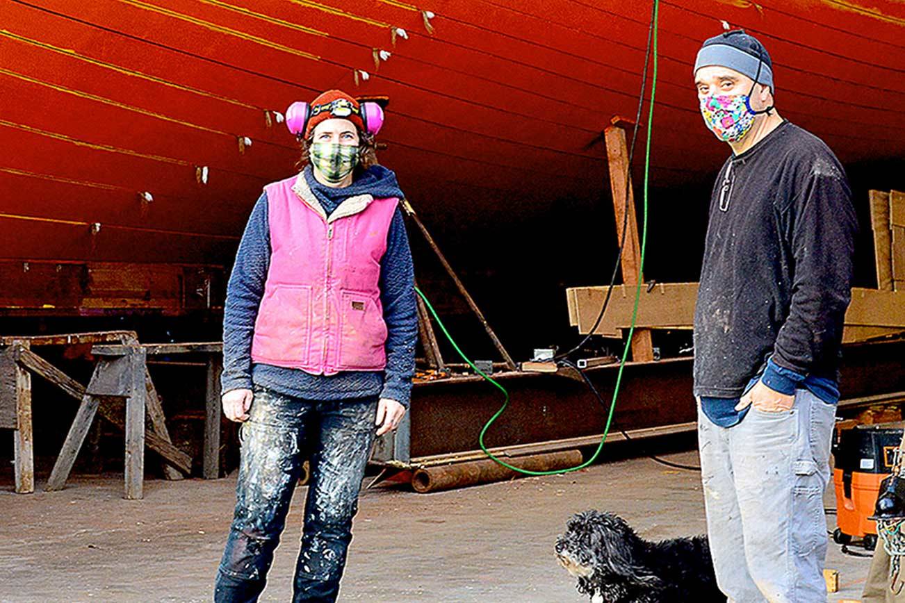 The Western Flyer, made famous in John Steinbeck's "The Log from the Sea of Cortez," is being restored at the Shipwrights Cooperative in Port Townsend with Ginny Wilson, Tim Lee and Tuff the dog on the crew. A tour of the project is one of the items in the Jefferson County Historical Society's AHA Auction wrapping up this weekend. (Diane Urbani de la Paz/Peninsula Daily News)