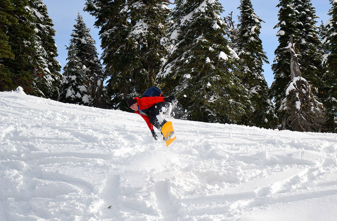A snowboarder hits a jump on a ski trail at Hurricane Ridge on Friday, Nov. 27, 2020. (Laura Foster/Peninsula Daily News)
