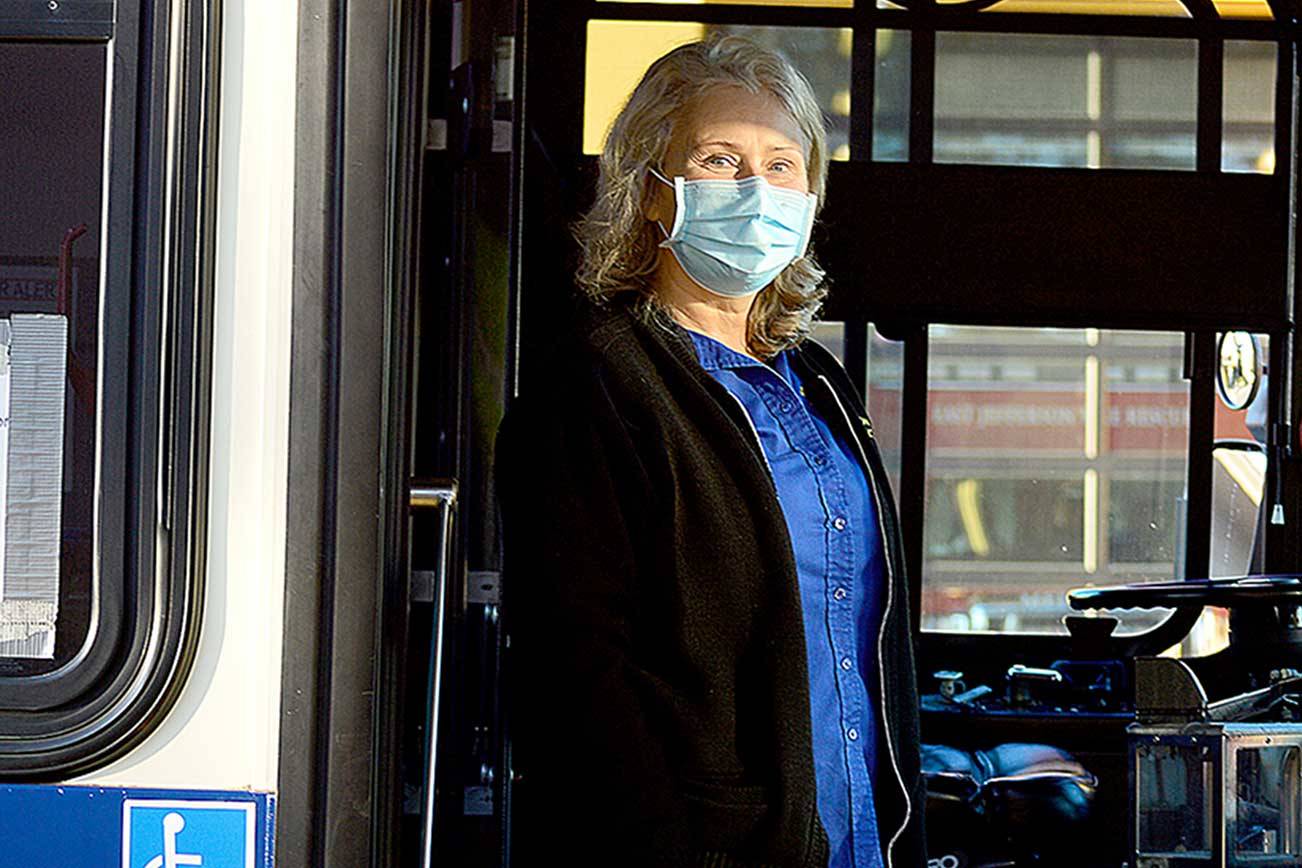 Jefferson Transit operator Linda Baumgaertner steps out from behind the barrier around her driver's seat. (Diane Urbani de la Paz/Peninsula Daily News)