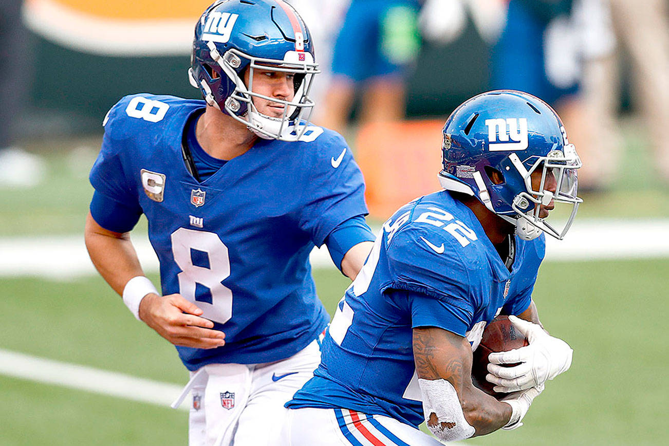 New York Giants quarterback Daniel Jones (8) hands the ball off to running back Wayne Gallman (22) during an NFL football game against the Cincinnati Bengals, Sunday, Nov. 29, 2020, in Cincinnati. The Giants won 19-17. (AP Photo/Aaron Doster)
