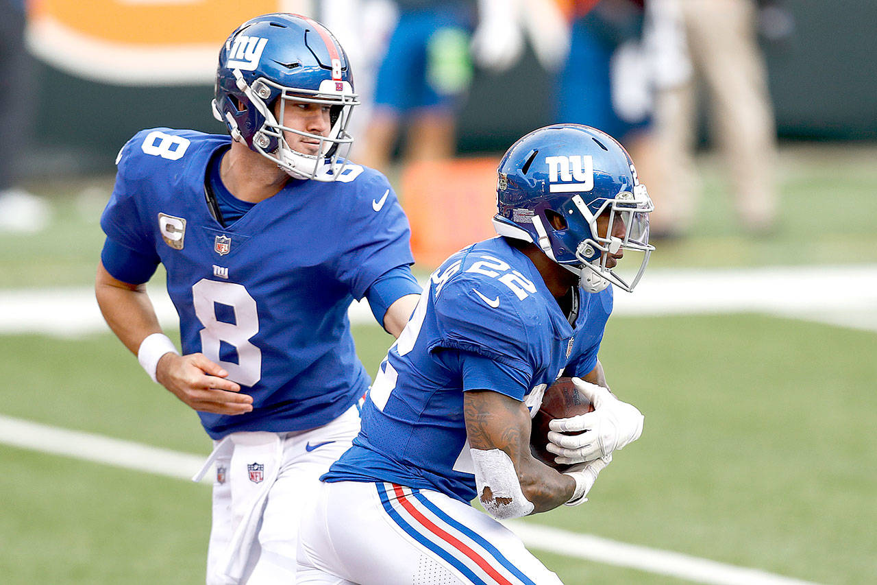 New York Giants quarterback Daniel Jones (8) hands the ball off to running back Wayne Gallman (22) during an NFL football game against the Cincinnati Bengals, Sunday, Nov. 29, 2020, in Cincinnati. The Giants won 19-17. (AP Photo/Aaron Doster)