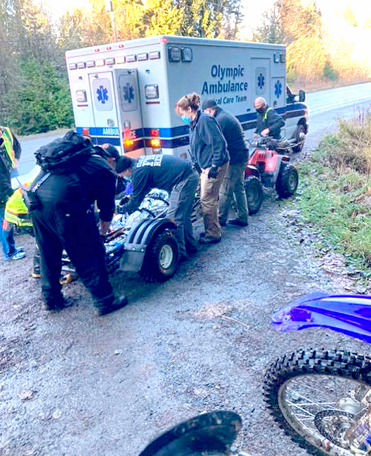An injured biker is treated Saturday by Clallam Fire District No. 2 personnel after being brought down from the backcountry after a wreck. (Photo courtesy of Mike McVaugh)