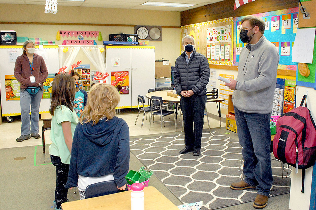 State Rep. Mike Chapman, right, speaks to first-grade students during a Thursday tour of Crescent School in Joyce as school Superintendent Dave Bingham, second from right, looks on. Chapman visited the school to see how the district's hybrid system of in-class and remote instruction was working and to discuss school funding issues. Crescent currently makes in-person instruction available to students in kindergarten through sixth grade with middle and high school students on campus on a two-day-per-week schedule intermixed with remote learning. All parents are given the option of remote instruction for their children. (Keith Thorpe/Peninsula Daily News)