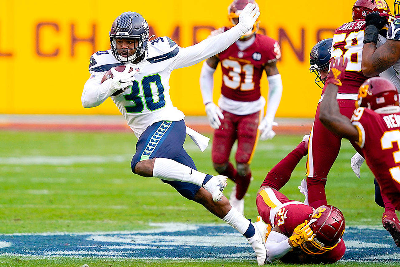 Seattle Seahawks running back Carlos Hyde (30) breaks away from Washington Football Team cornerback Ronald Darby (23) to begin his 50-yard touchdown run during the second half of an NFL football game, Sunday, Dec. 20, 2020, in Landover, Md. (AP Photo/Susan Walsh)