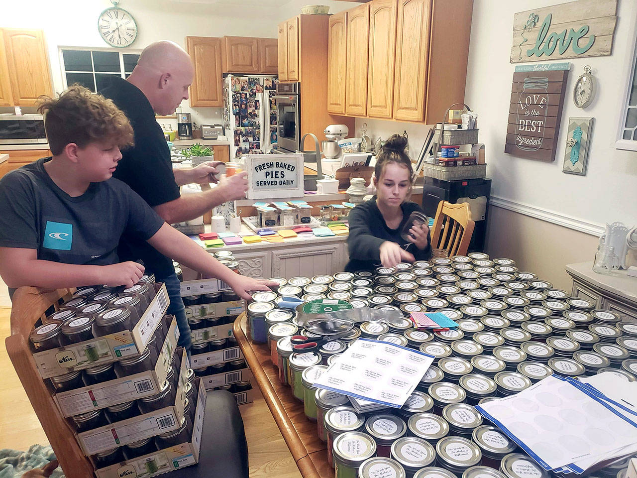 The family of Leslee Francis, Olympic Peninsula Healthy Communities Coalition executive director, son, Austin, 11, husband, Doug, and daughter ,Savannah, 13, help arrange 350 “jars of kindness” for disitribution to Clallam County behavioral health workers. (Courtesy photo)