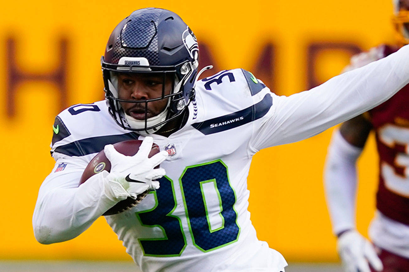 Seattle Seahawks running back Carlos Hyde (30) breaks away from Washington Football Team cornerback Ronald Darby (23) to begin his 50-yard touchdown run during the second half of an NFL football game Dec. 20 in Landover, Md. (Susan Walsh/The Associated Press)