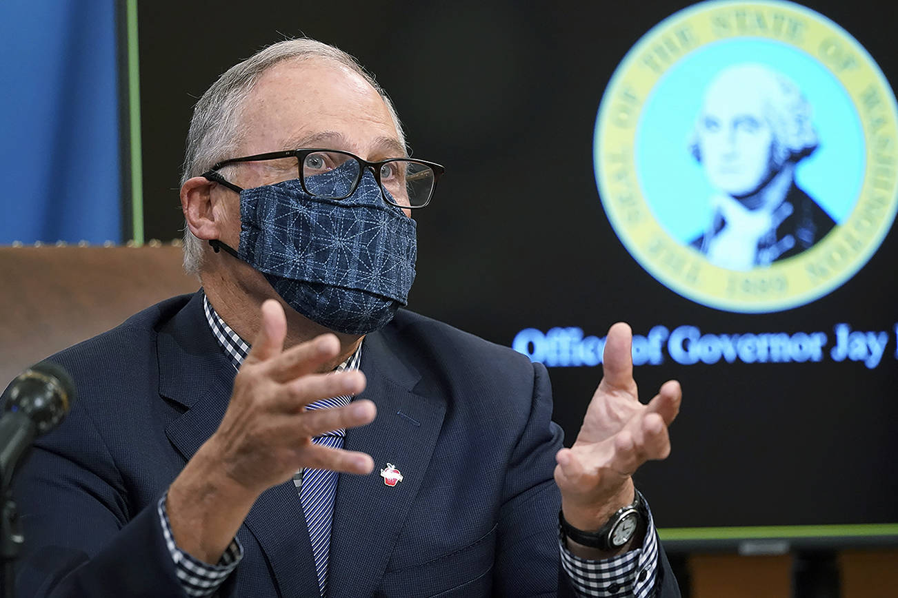 FILE - In this Dec. 17, 2020 file photo, Washington Gov. Jay Inslee talks to reporters at the Capitol in Olympia, Wash.  State lawmakers across the country will be convening in 2021 with the continuing COVID-19 pandemic rippling through much of their work — and even affecting the way they work. After 10 months of emergency orders and restrictions from governors and local executive officials, some state lawmakers are eager to reassert their power over statewide decisions shaping the way people shop, work, worship and attend school  (AP Photo/Ted S. Warren, File)