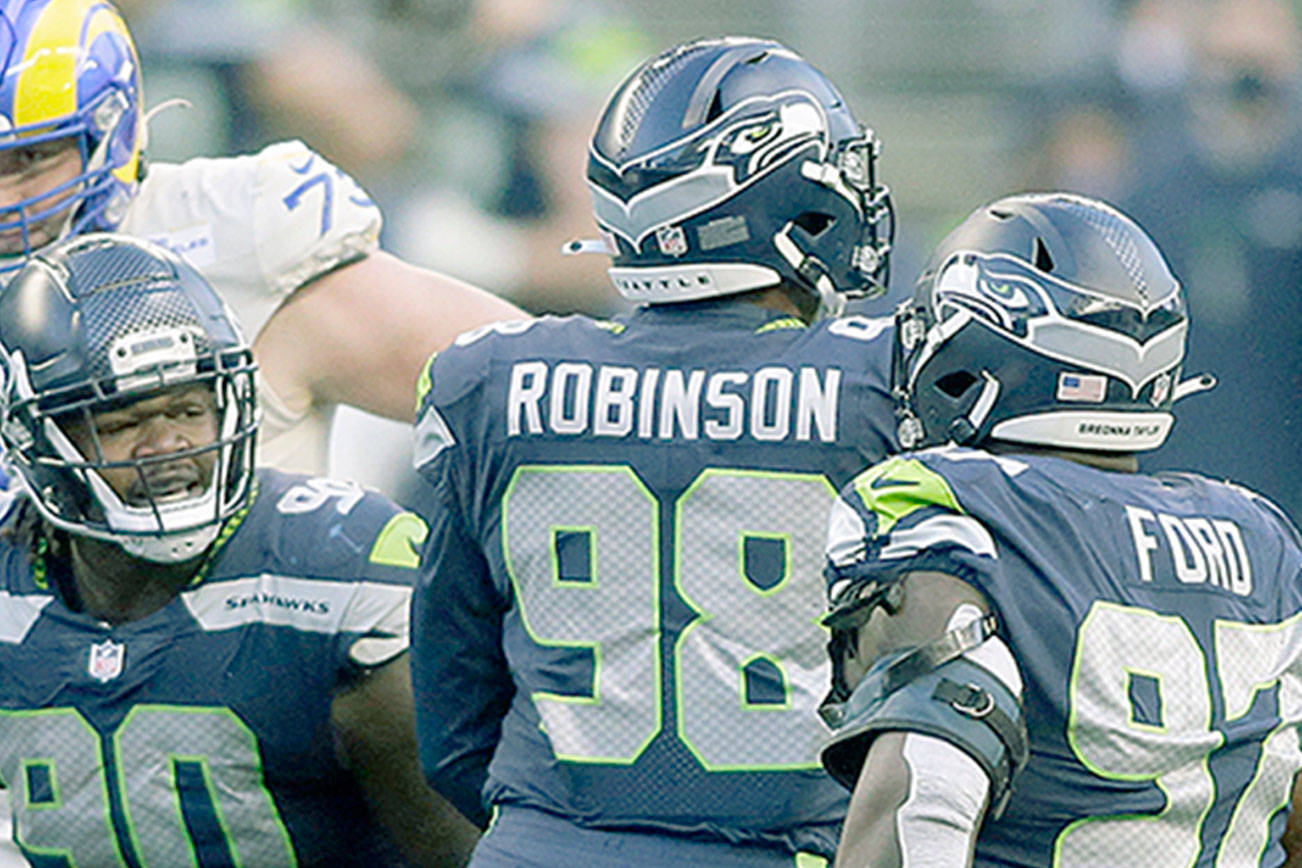 Seattle Seahawks defensive end Alton Robinson (98) reacts with teammates after he sacked Los Angeles Rams quarterback Jared Goff (16) during the second half of an NFL football game, Sunday, Dec. 27, 2020, in Seattle. (Scott Eklund/The Associated Press)